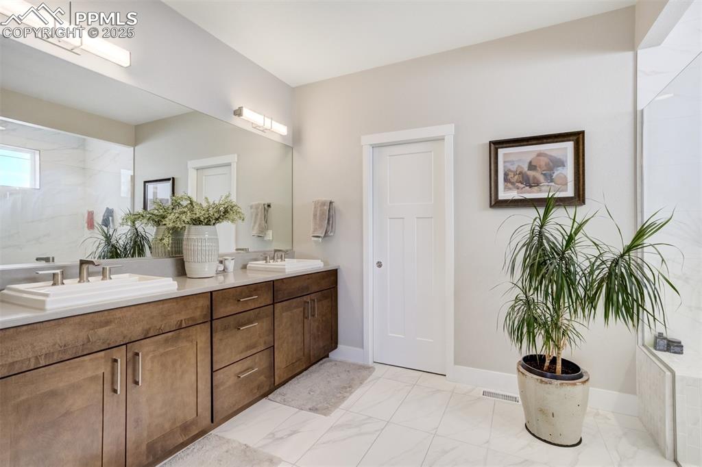 Image 22 of 50: Primary features a Double vanity and large walk-in closet with custom shelv
