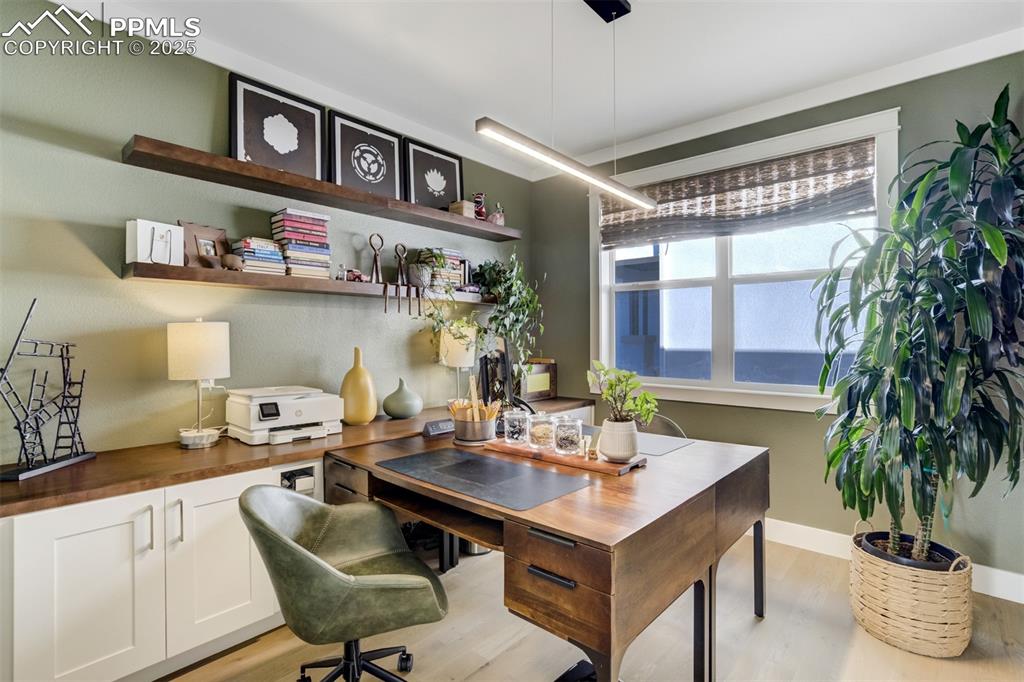 Image 23 of 50: Dedicated office with built in cabinetry and floating shelves 