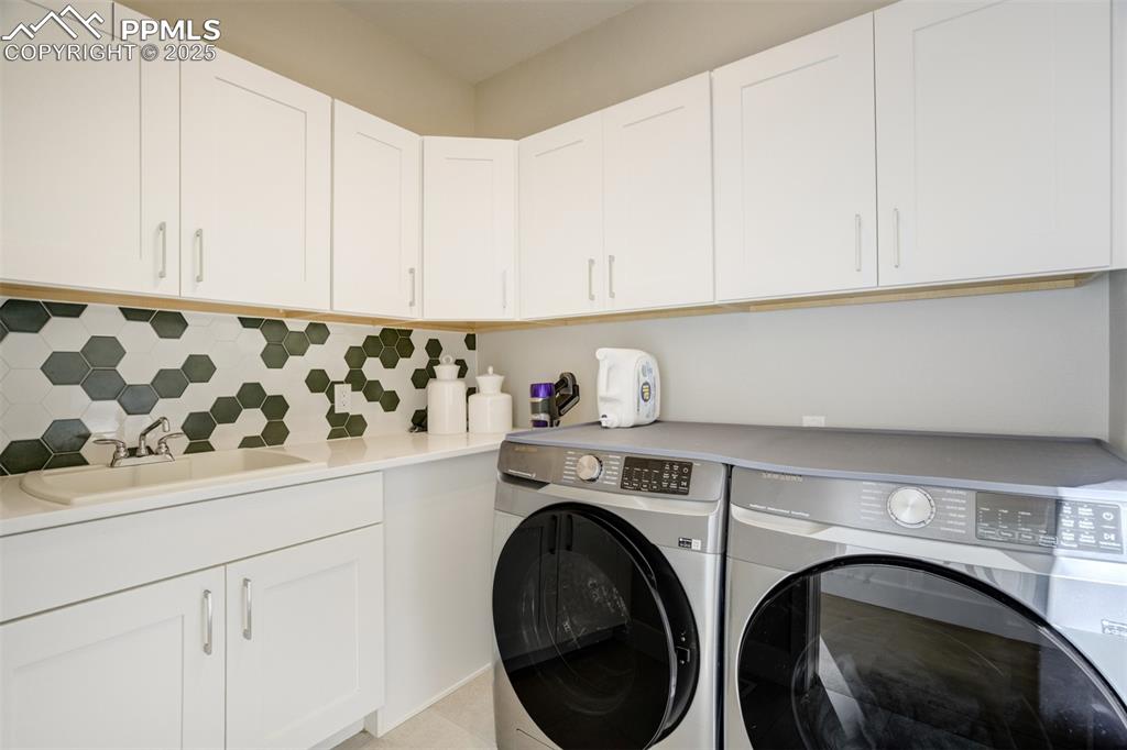 Image 24 of 50: Main level laundry with extra storage space and a sink