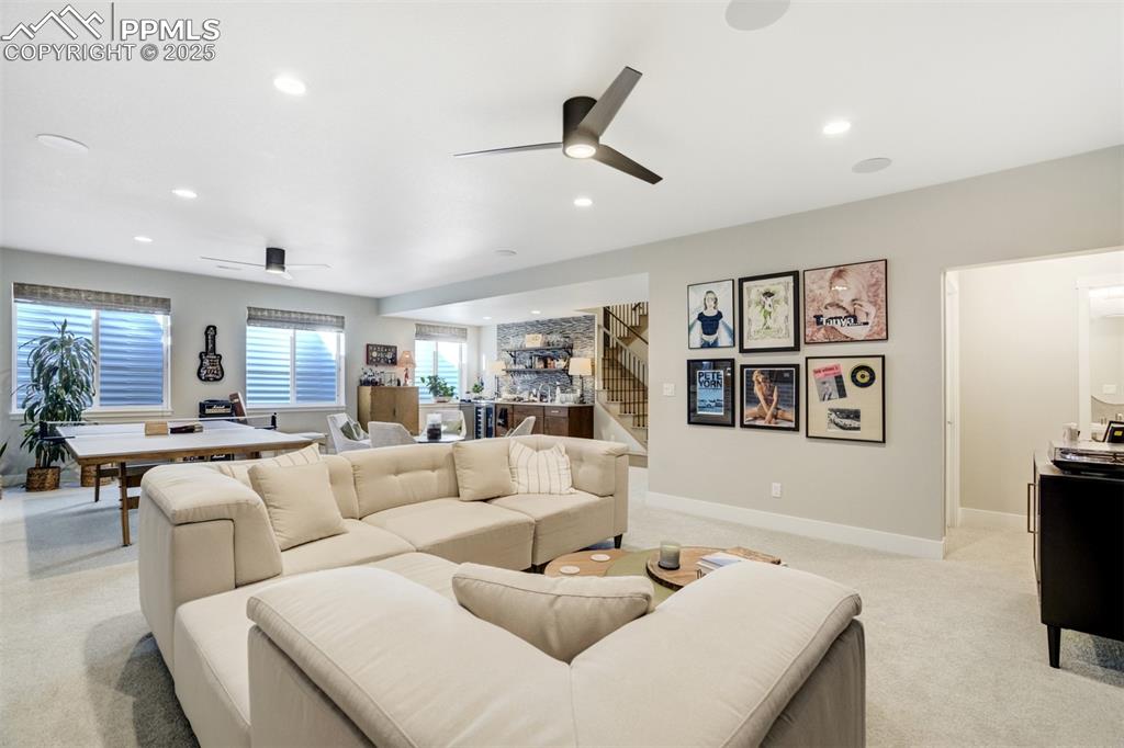 Image 31 of 50: A second living area in basement with high ceilings and light!