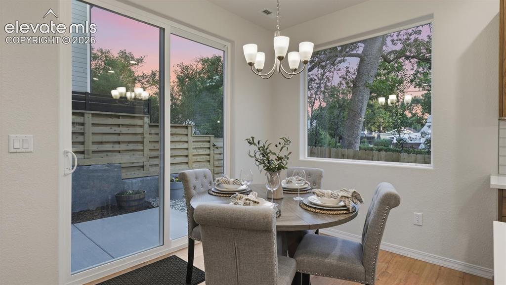 Image 11 of 50: Spacious Island Kitchen with breakfast bar, pendant lights, sleek cabinetry