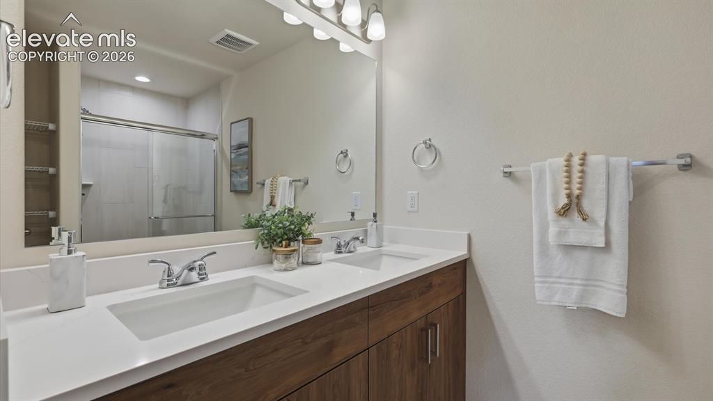 Image 23 of 50: The upper level Primary Bathroom includes a dual sink vanity, mirror, and e