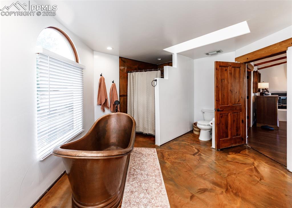 Image 25 of 50: Hall featuring concrete flooring, beam ceiling, and recessed lighting