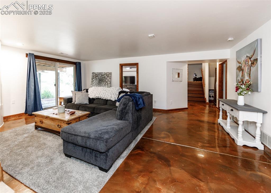 Image 30 of 50: Living room with concrete floors and stairs