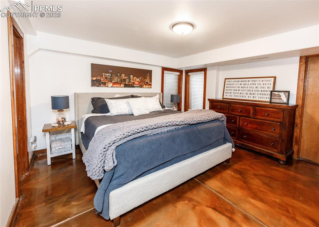 Image 36 of 50: Bedroom featuring concrete floors and baseboards