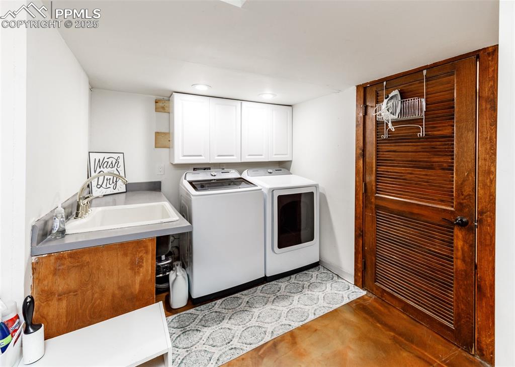 Image 39 of 50: Laundry room featuring cabinet space and washing machine and clothes dryer