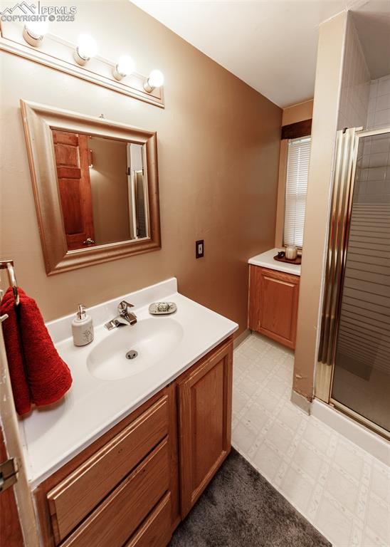 Image 42 of 50: Full bath with vanity, light floors, and a stall shower