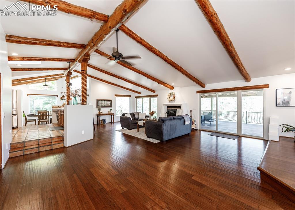 Image 7 of 50: Living area with dark wood finished floors, a glass covered fireplace, and 