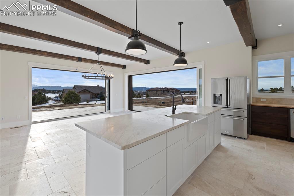 Image 18 of 47: Kitchen with white cabinets, stone tile flooring, a sink, stainless steel r