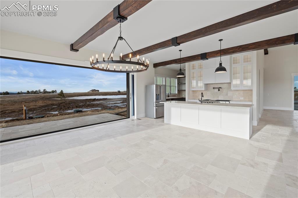 Image 19 of 47: Kitchen with a notable chandelier, light countertops, stainless steel fridg