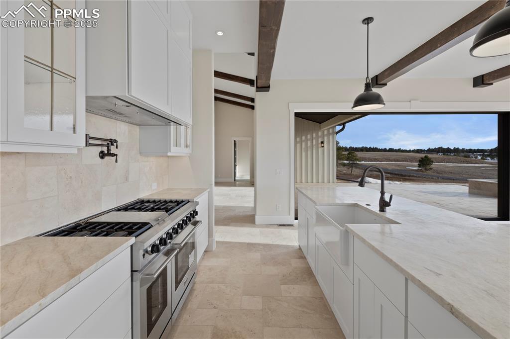 Image 21 of 47: Kitchen featuring a sink, double oven range, tasteful backsplash, light sto