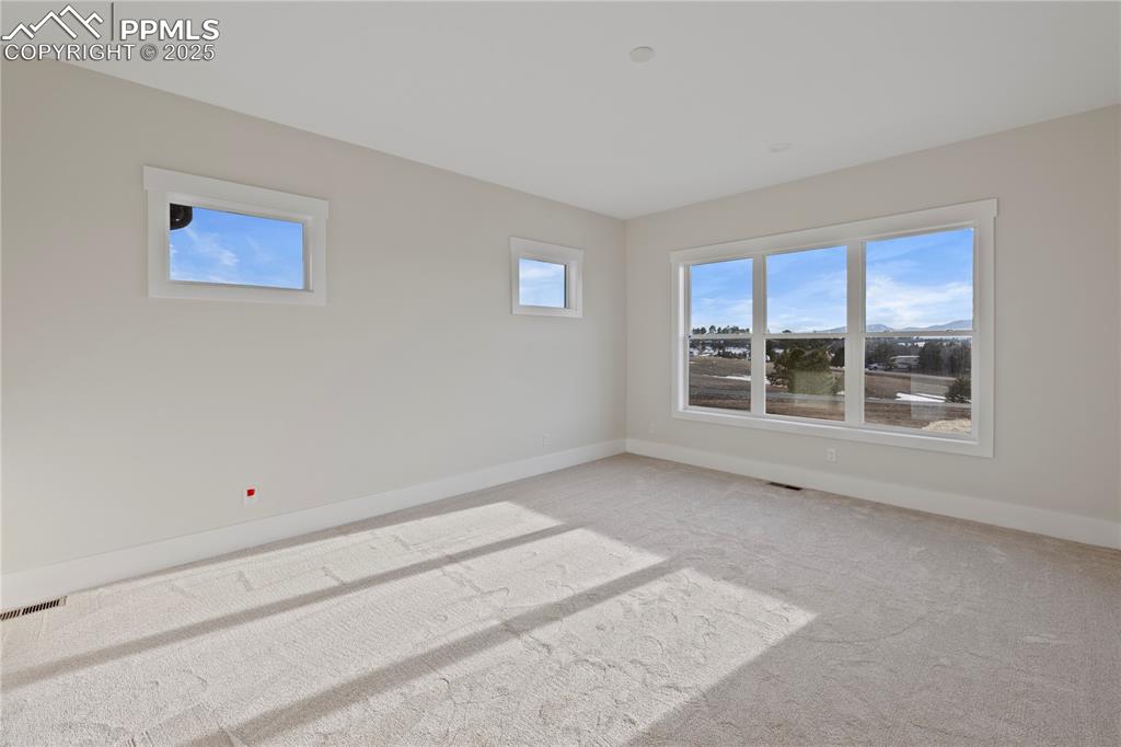 Image 33 of 47: Empty room with baseboards, visible vents, and light colored carpet