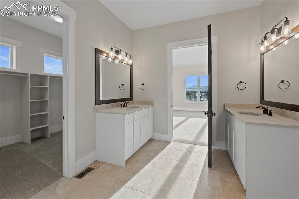 Image 37 of 47: Bathroom with a sink, visible vents, two vanities, and plenty of natural li