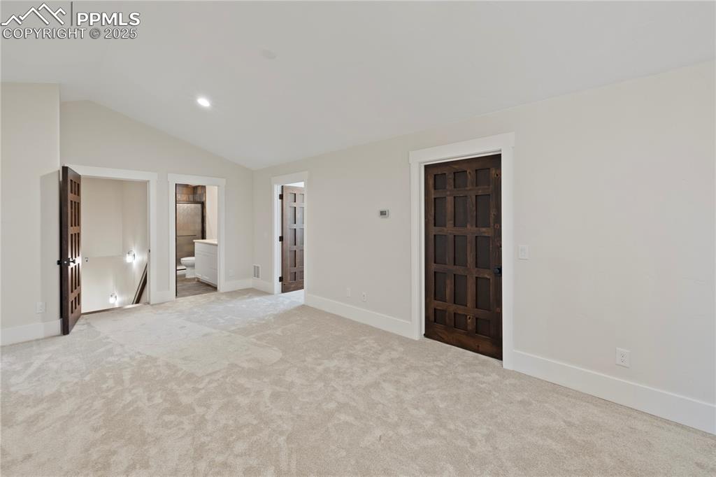 Image 44 of 47: Empty room with carpet floors, baseboards, lofted ceiling, and recessed lig