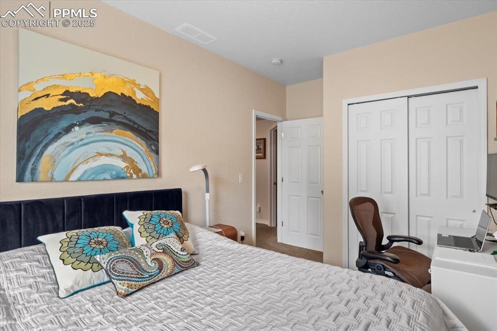 Image 27 of 37: Carpeted bedroom with visible vents and a closet