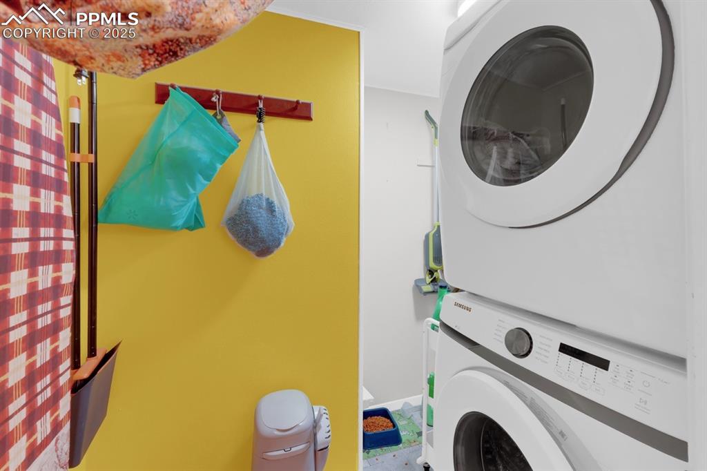 Image 13 of 27: Laundry room featuring stacked washer / dryer