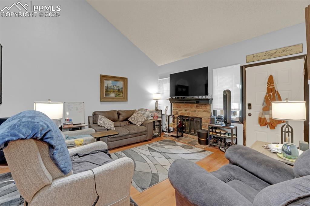 Image 5 of 27: Living room featuring wood finished floors, high vaulted ceiling, and a fir