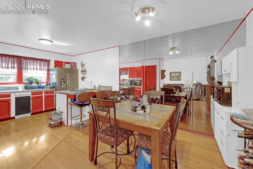 Image 8 of 27: Dining Area with Wood Floors and Mirrored Wall