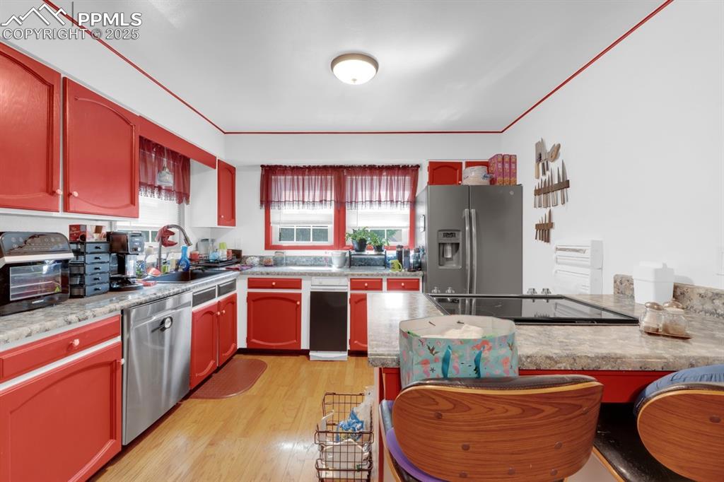 Image 9 of 27: Kitchen featuring stainless steel appliances & hardwood floors