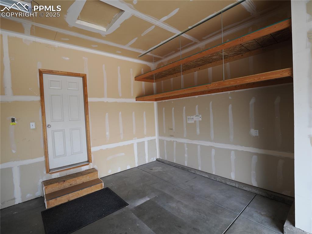 Image 45 of 49: Kick out storage space in garage and storage shelves 