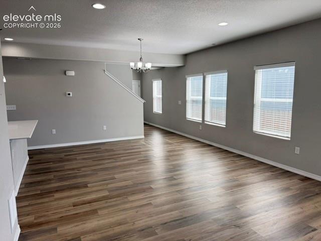 Image 11 of 42: Open concept living space featuring wood-finish flooring, multiple windows