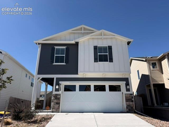 Image 2 of 42: Two-story exterior with a mixed siding facade, prominent white garage door,