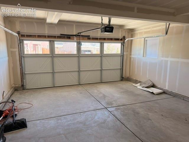 Image 20 of 42: Concrete flooring, automatic garage door opener, and a panel-style garage d