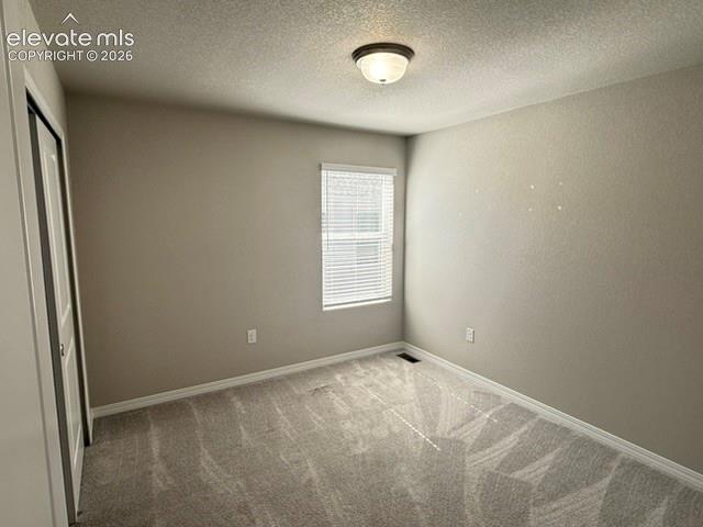 Image 26 of 42: Textured wall finish with neutral paint, wall-to-wall carpeting, and a ceil