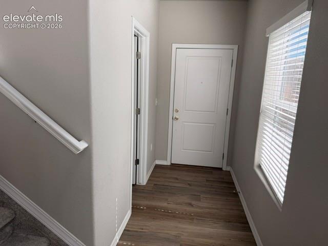 Image 3 of 42: Wood-finish flooring, white paneled door, vertical window blinds, and stair