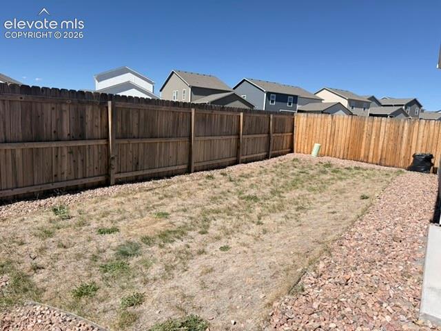 Image 36 of 42: Fully fenced backyard with wood fencing and a gravel perimeter