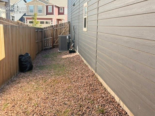 Image 39 of 42: Horizontal siding with a textured finish, wood privacy fence, and gravel gr
