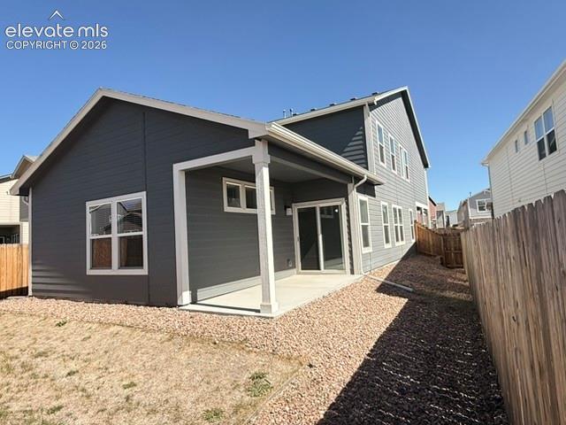 Image 42 of 42: Exterior featuring dark gray siding, white trim, covered patio, sliding gla