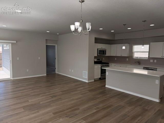 Image 6 of 42: Open-concept living space featuring wood-finish flooring, recessed lighting