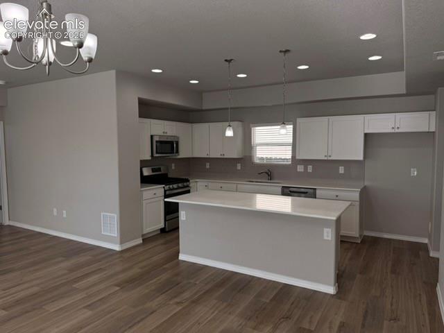 Image 7 of 42: Kitchen featuring white cabinetry, stainless steel appliances, a center isl