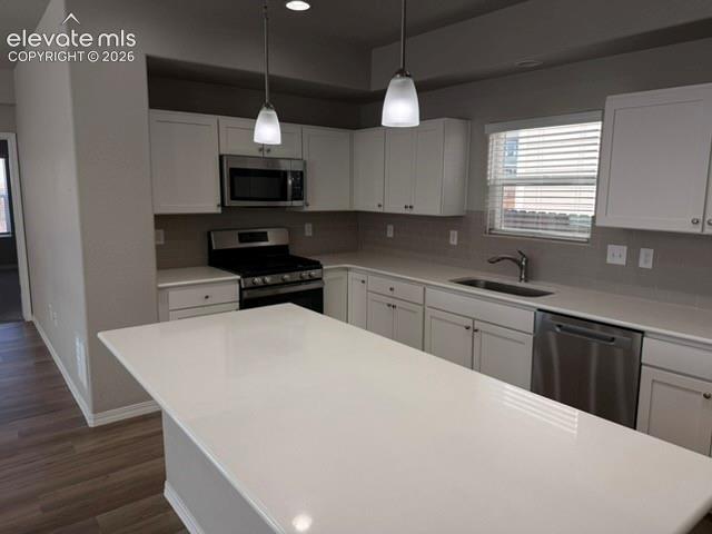 Image 8 of 42: Kitchen featuring a large island, white cabinetry, stainless steel applianc
