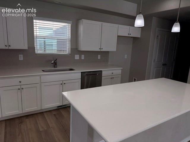 Image 9 of 42: White shaker cabinetry, light-toned countertops, stainless steel dishwasher