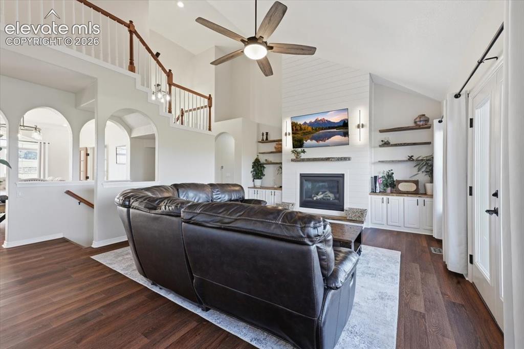 Image 7 of 36: Living room with gas fireplace, built ins and walkout to deck