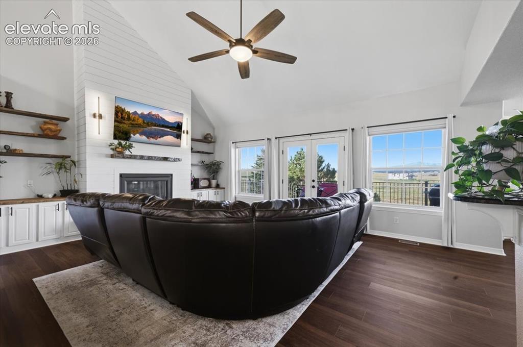 Image 8 of 36: living room with gas fireplace, built ins and walkout to deck