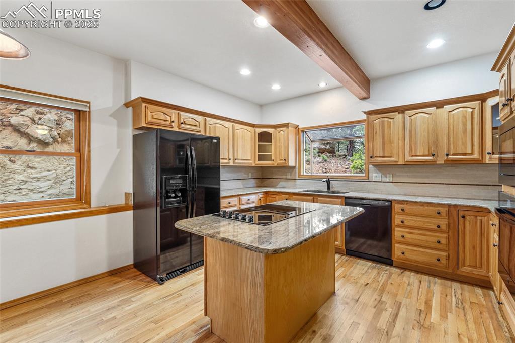 Image 10 of 48: Kitchen featuring black appliances, beam ceiling, a sink, light wood finish