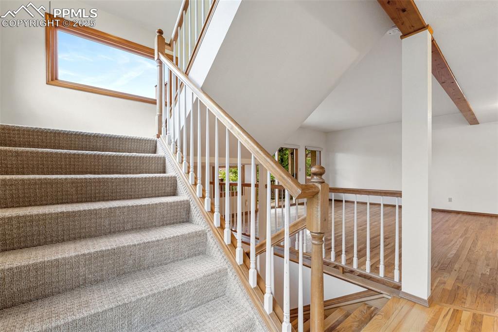 Image 18 of 48: Stairway featuring wood finished floors, plenty of natural light, and baseb