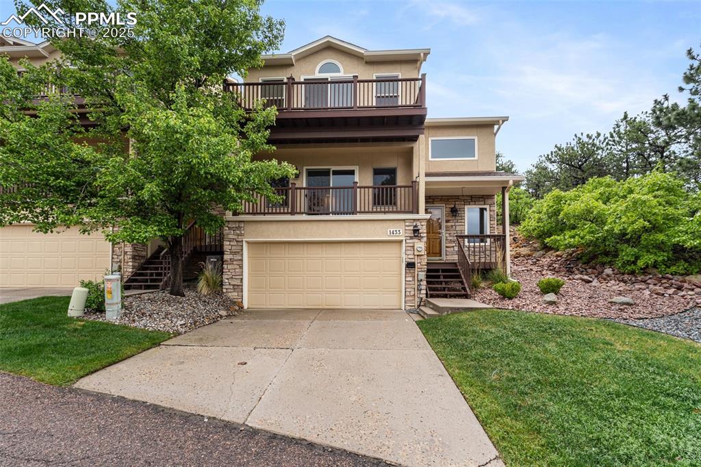 Image 2 of 48: View of front facade with stairway, stone siding, stucco siding, concrete d
