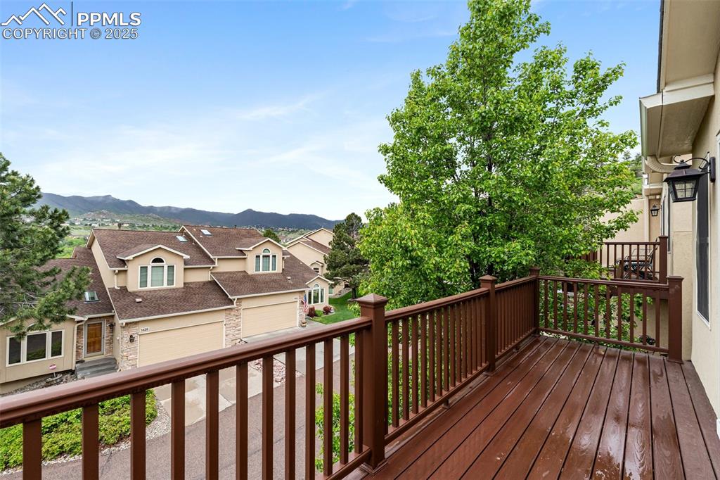 Image 25 of 48: Wooden terrace featuring a mountain view, a garage, and a residential view