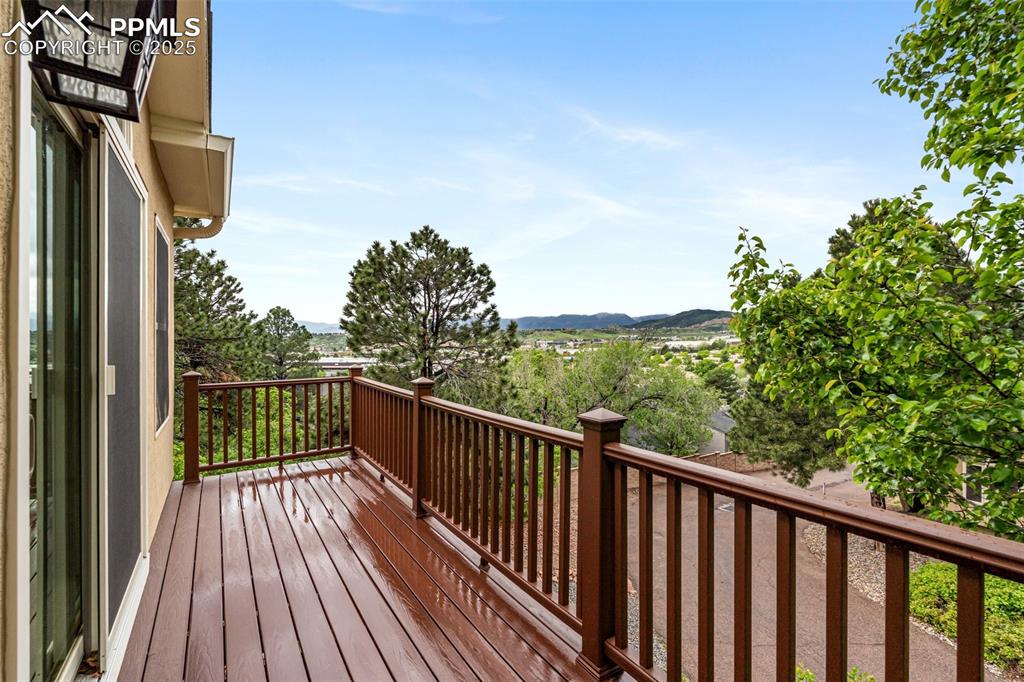Image 26 of 48: Primary suite composite deck with Pikes Peak views and mature trees