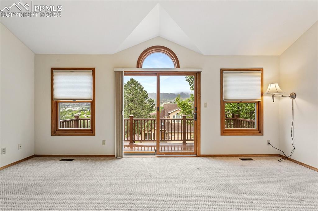 Image 27 of 48: Spare room featuring carpet flooring, vaulted ceiling, and baseboards