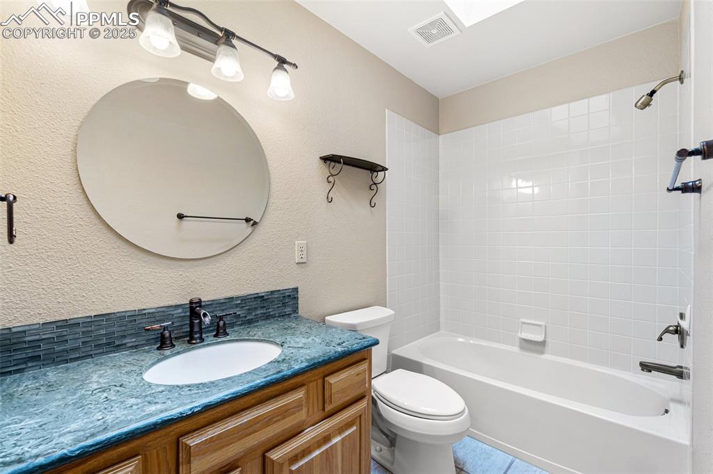 Image 30 of 48: Full bath with vanity, toilet, and shower combination
