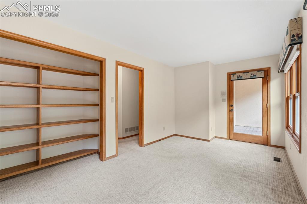 Image 34 of 48: Unfurnished bedroom with light carpet, baseboards, and access to exterior