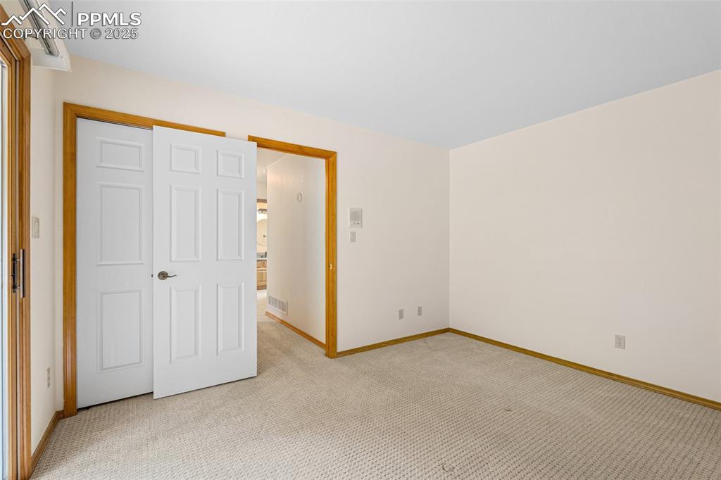 Image 35 of 48: Unfurnished bedroom with light colored carpet, baseboards, and a closet