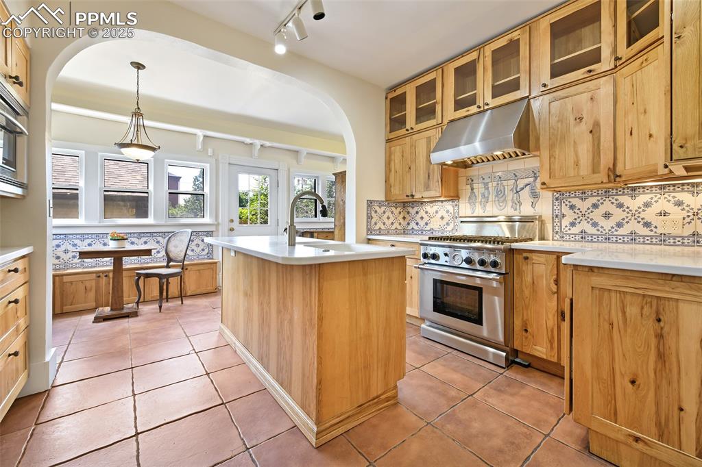 Image 14 of 42: Updated Kitchen boasts hickory cabinets, gas downdraft range, Corian counte