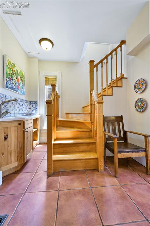 Image 33 of 42: Separate stairway off the kitchen takes you to the upper deck and loft