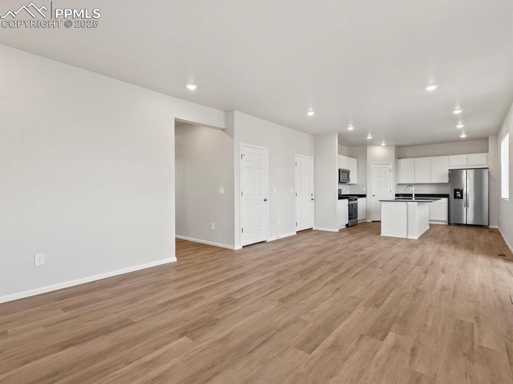 Image 10 of 24: Unfurnished living room featuring recessed lighting and light wood-type flo